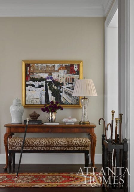 Entryway with console table, leopard print bench, painting, and umbrella stand
