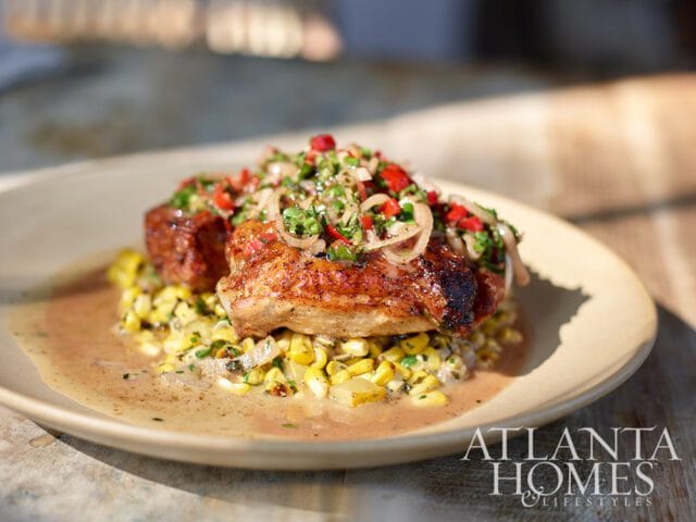Chicken with corn and salsa topping on a plate with Atlanta Homes & Lifestyles logo