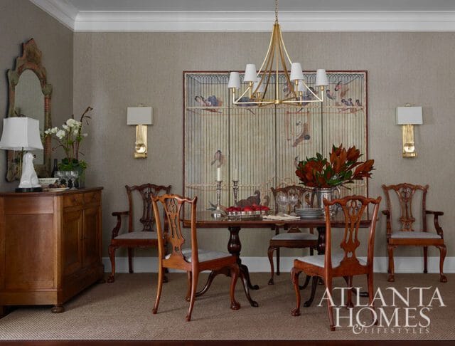 Dining room with antique wooden chairs, a dark wood table, and a large birdcage painting.