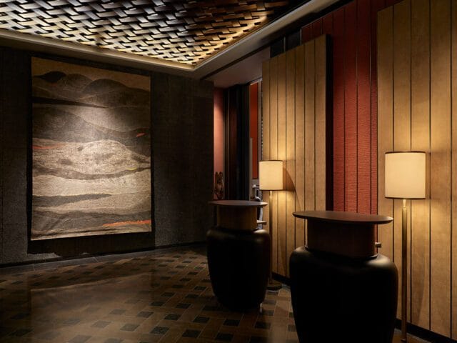 Lobby with textured ceiling, large abstract art, and wood-paneled walls