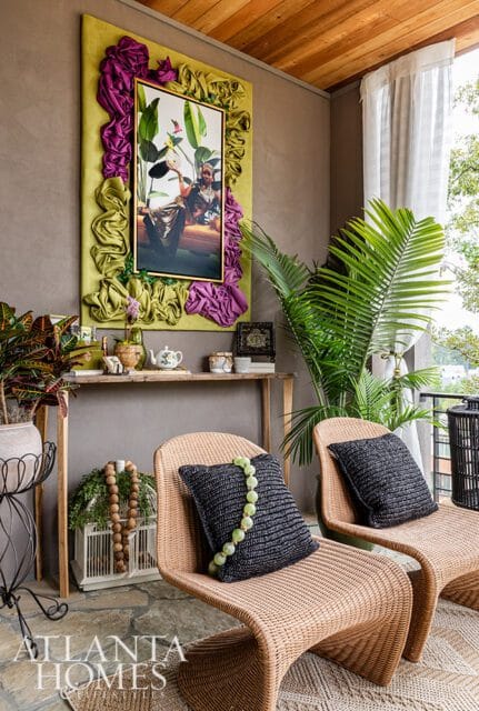 Wicker chairs with dark pillows and green bead garland, console table with art