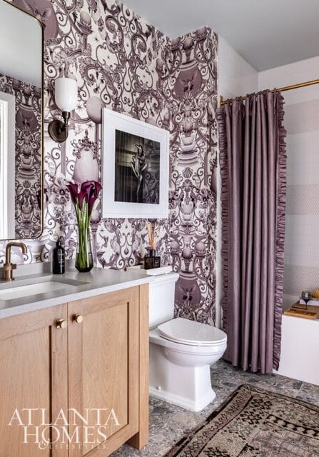 Bathroom with purple patterned wallpaper, wood vanity, white toilet, and ruffled purple shower
