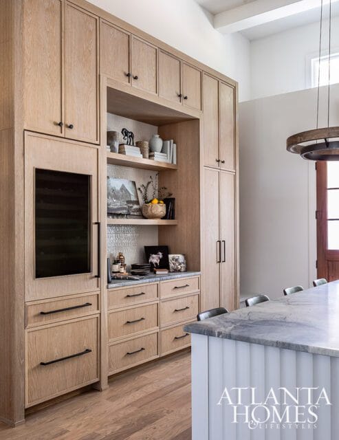 Light wood built-in cabinetry with open shelves displaying decor and a wine fridge.
