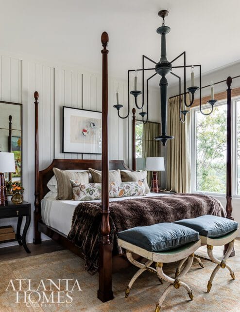 Bedroom with dark wood four-poster bed, brown fur throw, and teal benches.
