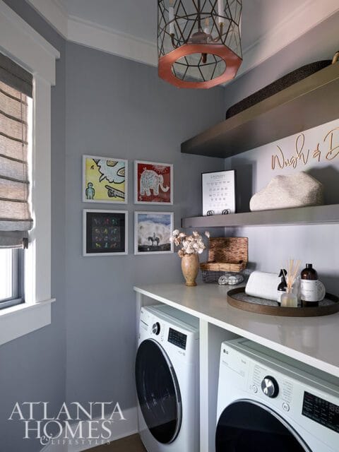 Laundry room with gray walls, white LG washer and dryer, and decorative art.