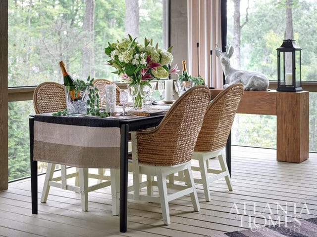 Dining table with wicker chairs, champagne bucket, floral arrangement, and deer statue