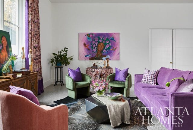 Living room with plush purple sofa, green armchairs with purple pillows, and a large abstract painting of a woman surrounded by birds.