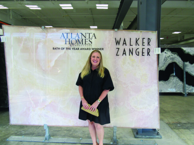 Woman in black dress standing in front of a large pink marble slab with Atlanta Homes & Lifestyles