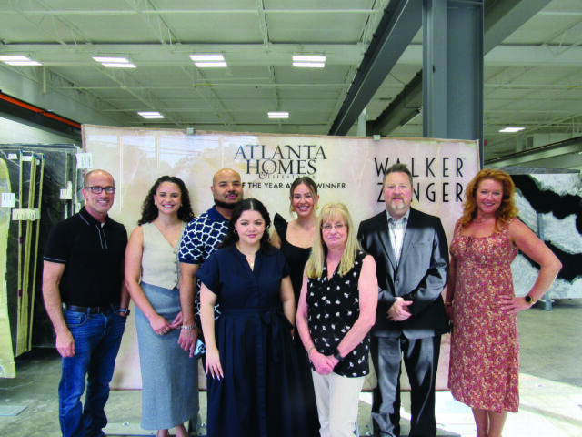 Group posing in front of Atlanta Homes & Lifestyles banner with Walker Zenger logo