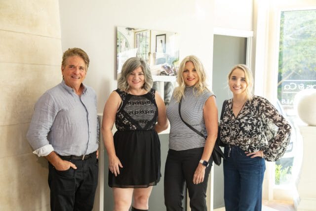 Four people posing for a photo indoors.