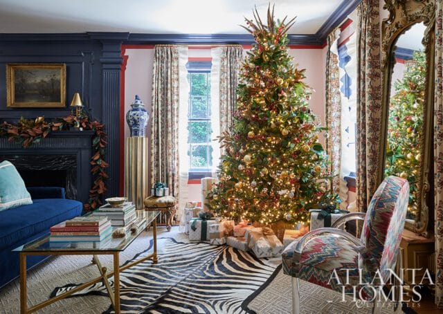 Living room with Christmas tree, blue sofa, glass coffee table, and zebra rug.