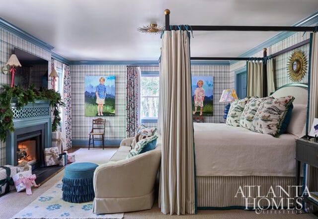 Bedroom with plaid wallpaper, four-poster bed, fireplace, and portraits of children.