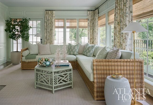 Light green living room with wicker sectional sofa, patterned curtains, and bamboo coffee table.
