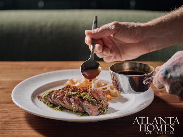 Sliced steak with green sauce being drizzled with sauce from a spoon.