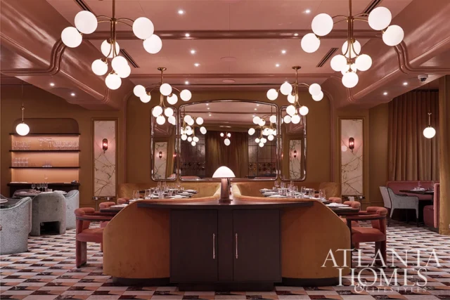 Dining room with plush banquettes, marble accents, and globe chandeliers.