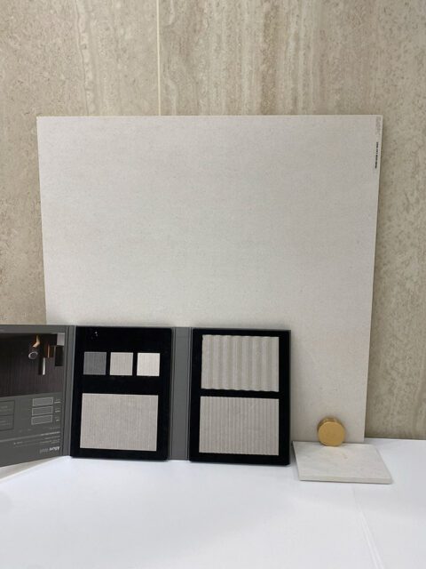 Tile samples and swatches in neutral tones, including ribbed and smooth finishes.