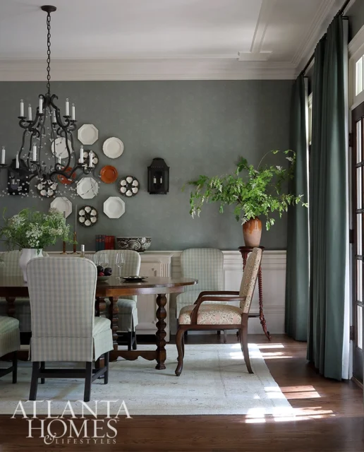 Dining room with checkered chairs, dark wood table, and ornate chandelier.