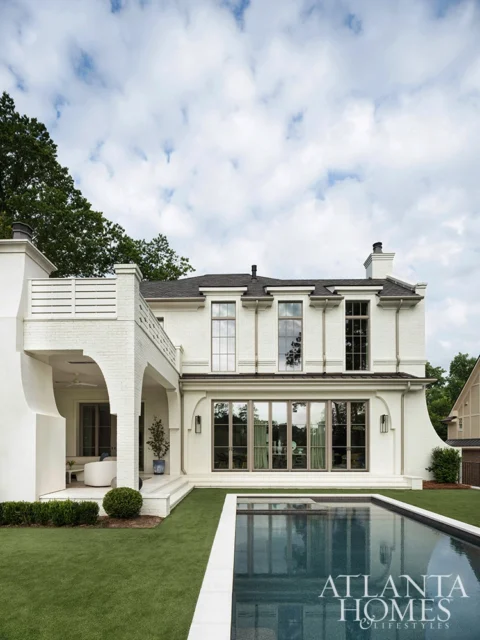 White brick house with pool and covered patio. Atlanta Homes & Lifestyles logo.