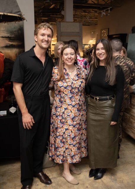 Man in black shirt and pants, woman in colorful dress, woman in black top and olive skirt