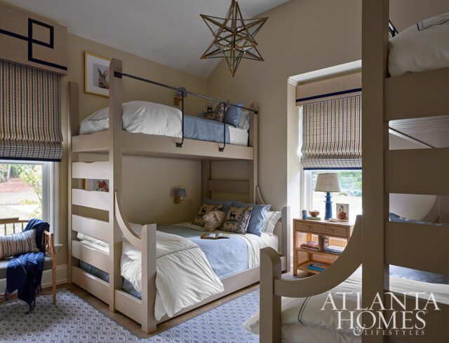 Tan bedroom with bunk beds, blue and white striped curtains, and starburst chandelier.
