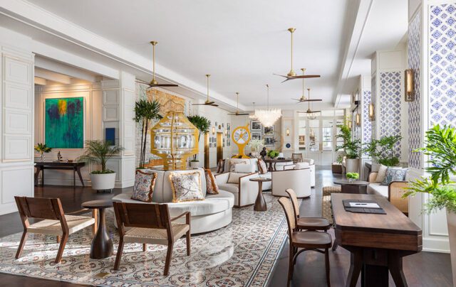 Lobby with white sofas, patterned rug, wooden chairs, and blue and white tile accents.