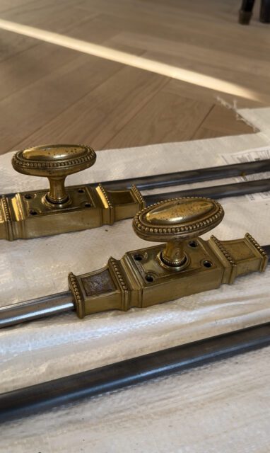 Brass window latches with oval knobs and decorative trim