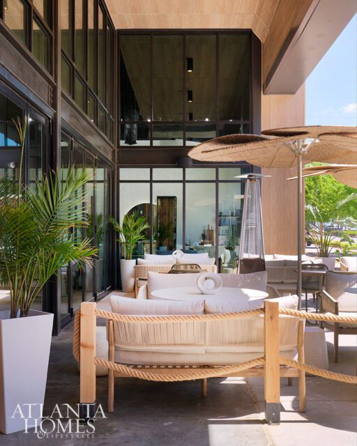 Outdoor seating area with white sofas, rope accents, and large umbrellas.