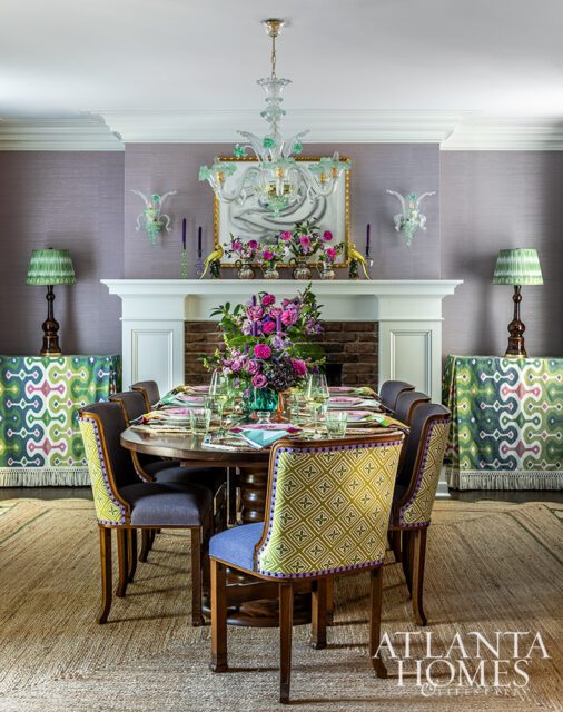 Dining room with purple walls, fireplace, and a table set for dinner.