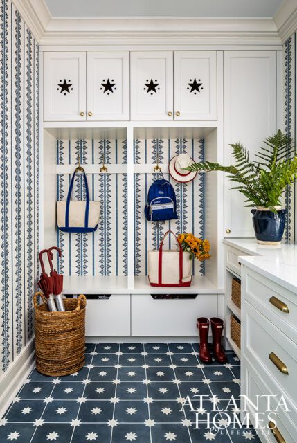 Mudroom with blue and white striped wallpaper, white cabinets with stars, and blue star tile floor.