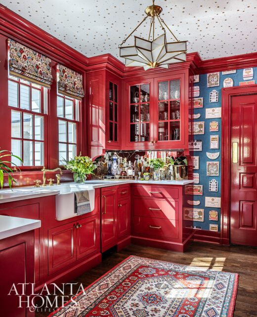 Red kitchen with patterned wallpaper, star-patterned ceiling, and ornate rug