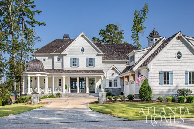 White shingle-sided house with blue shutters and a circular turret porch.