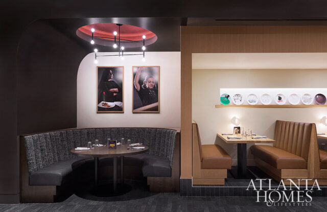 Restaurant interior with curved gray banquette, round table, and framed art.