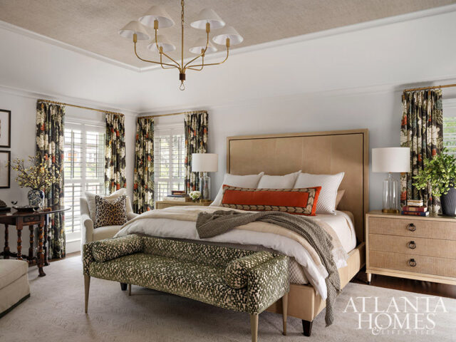 Bedroom with a king-size bed, floral curtains, and a patterned bench. Atlanta Homes & Lifestyles