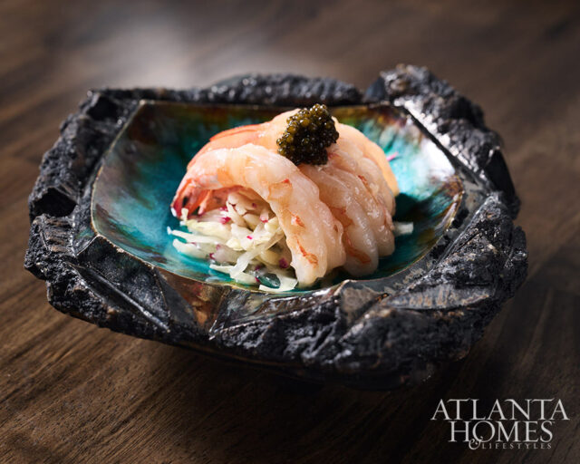 Shrimp and caviar appetizer in a textured black bowl with turquoise interior