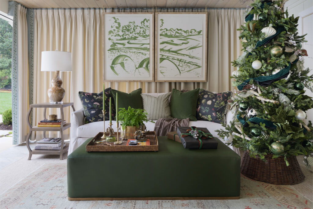 Living room with green ottoman, white sofa, and Christmas tree decorated with green ornaments and