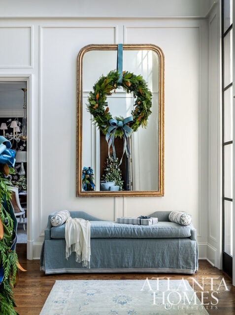 Blue chaise lounge with Christmas wreath on mirror above