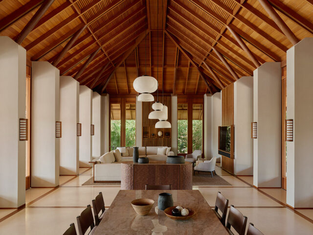 Living area with vaulted wood ceiling, cream sofas, and a marble dining table.