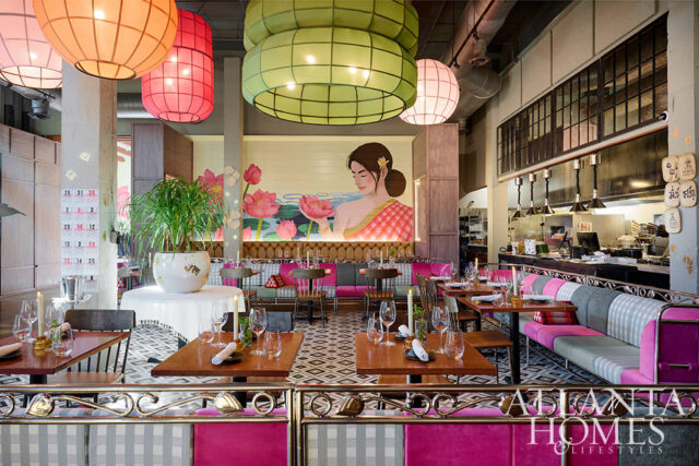 Restaurant dining room with colorful lanterns, mural of woman and lotuses, and pink banquette