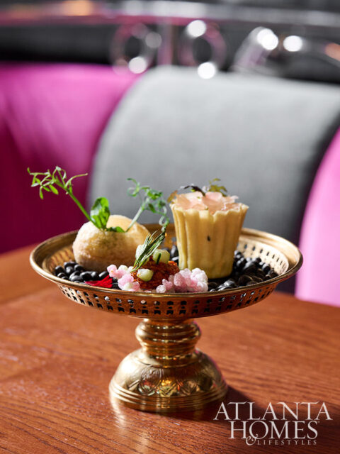 Brass footed tray with appetizers and pink and gray seating in background