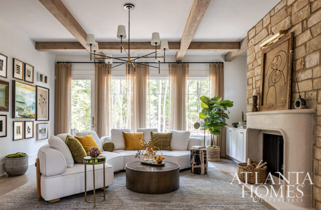 Living room with sectional sofa, round coffee table, stone fireplace, and gallery wall.