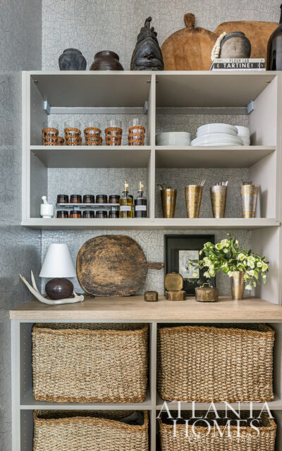 Shelving unit with woven baskets, glassware, spices, and decorative objects.