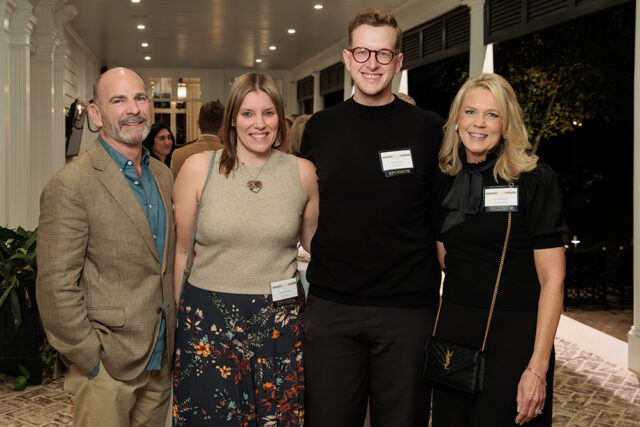 Four people posing for a photo, two men and two women, wearing name tags.