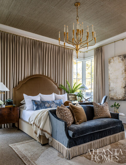 Bedroom with upholstered headboard, dark blue velvet sofa with fringe, and textured ceiling.