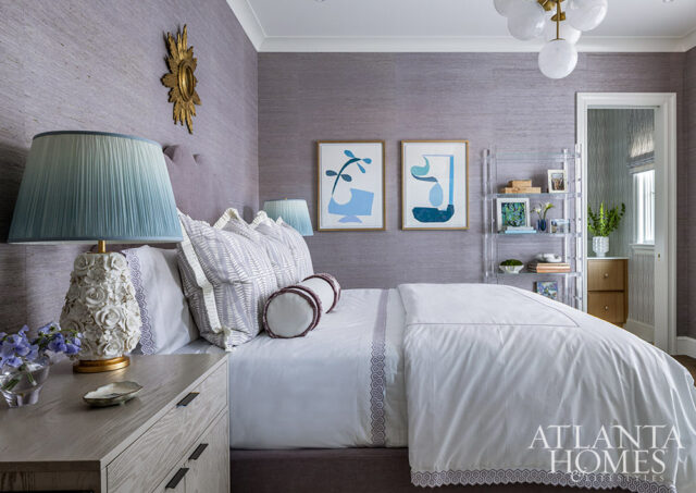 Purple textured wallpaper bedroom with white bedding, blue lamps, and abstract art.