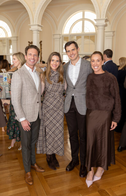 Two couples posing indoors with architectural arches in the background.