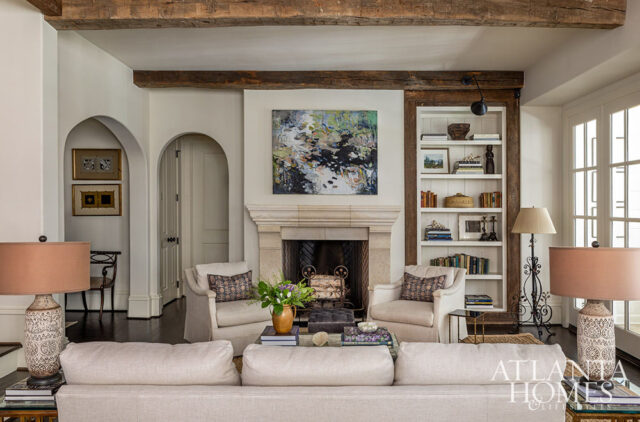 Living room with fireplace, built-in bookshelves, and neutral-toned sofa.