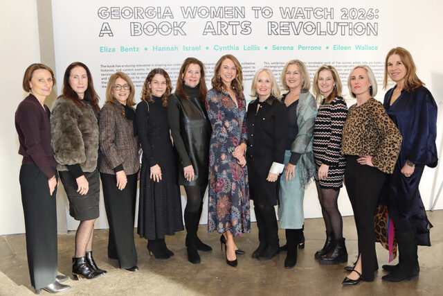 Group portrait of ten women standing in front of a wall with text that reads 'GEORGIA WOMEN TO WATCH 2026: A BOOK ARTS REVOLUTION' and names including Eliza Bentz, Hannah Israel, Cynthia Lollis, Serena Perrone, and Eileen Wallace.