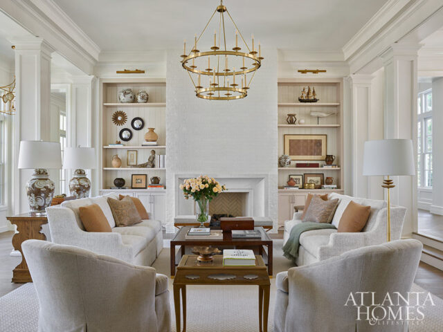 Living room with white brick fireplace, built-in shelves, and two sofas.