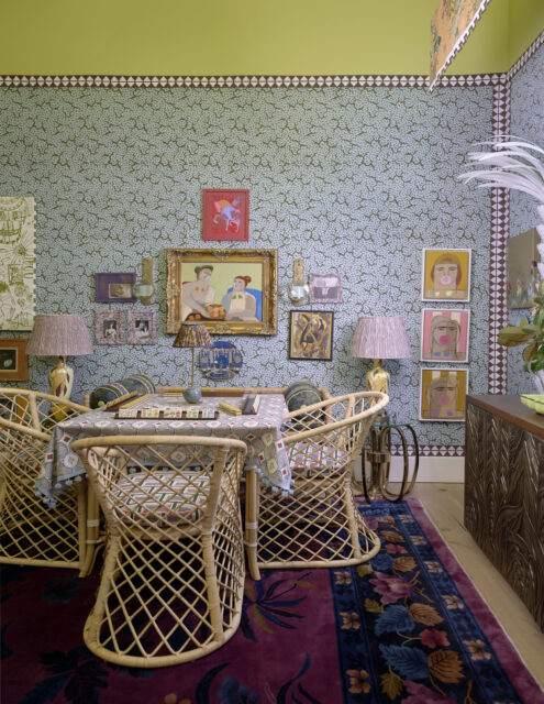 Dining room with rattan chairs, patterned tablecloth, and eclectic art on walls