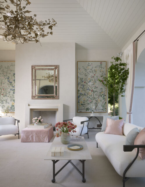 Living room with white sofa, chairs, fireplace, and floral wallpaper.